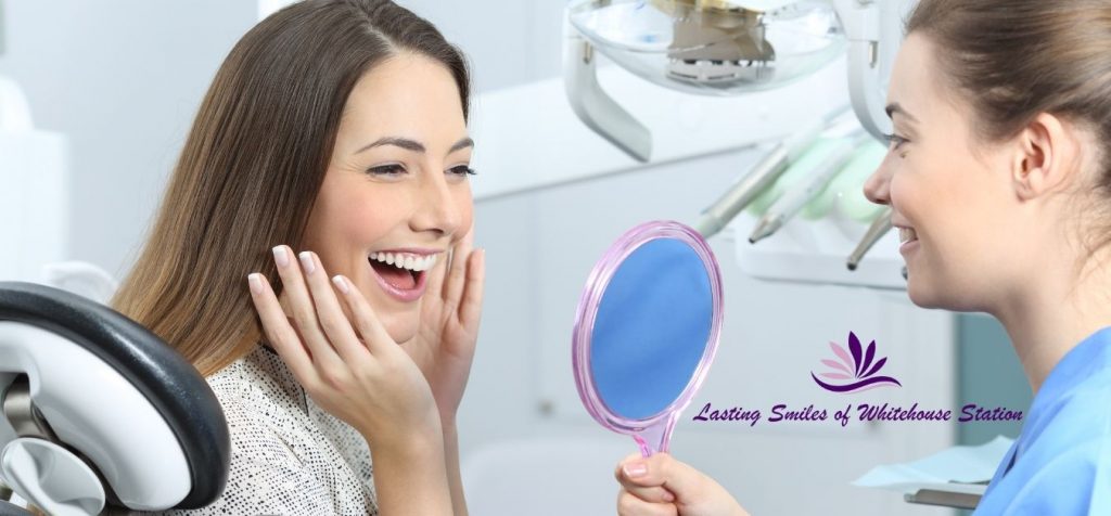 Patient looking at her new smile in the mirror.